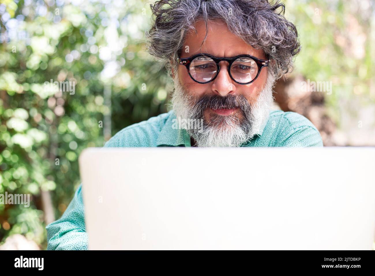 Portrait d'un homme avec des cheveux gris et une barbe travaillant sur l'ordinateur portable Banque D'Images