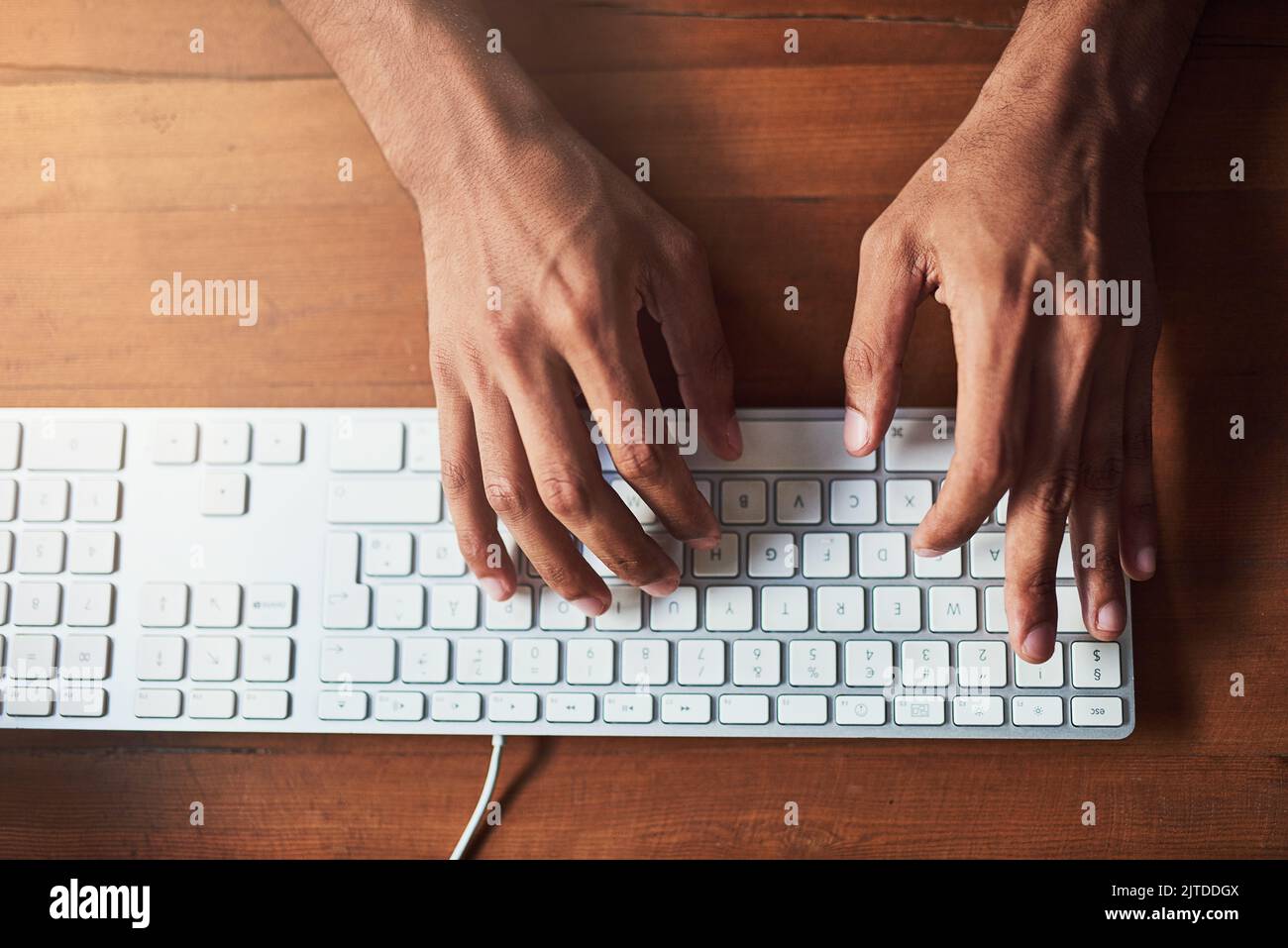 Prenez le contrôle grâce à la technologie. Prise de vue en grand angle d'un homme non identifiable tapant sur un clavier à un bureau. Banque D'Images