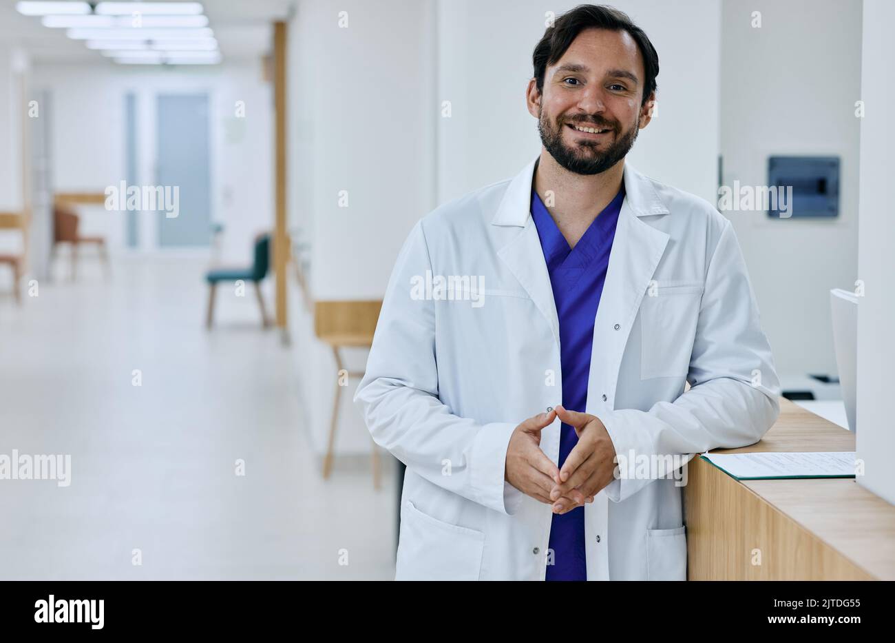 Médecin généraliste masculin amical portant l'uniforme médical debout dans la clinique médicale moderne, portrait. profession de médecin Banque D'Images