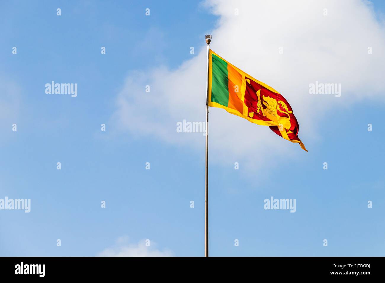 Le drapeau du Sri Lanka ou le drapeau Sinha est sur un mât sous ciel nuageux par une journée ensoleillée Banque D'Images