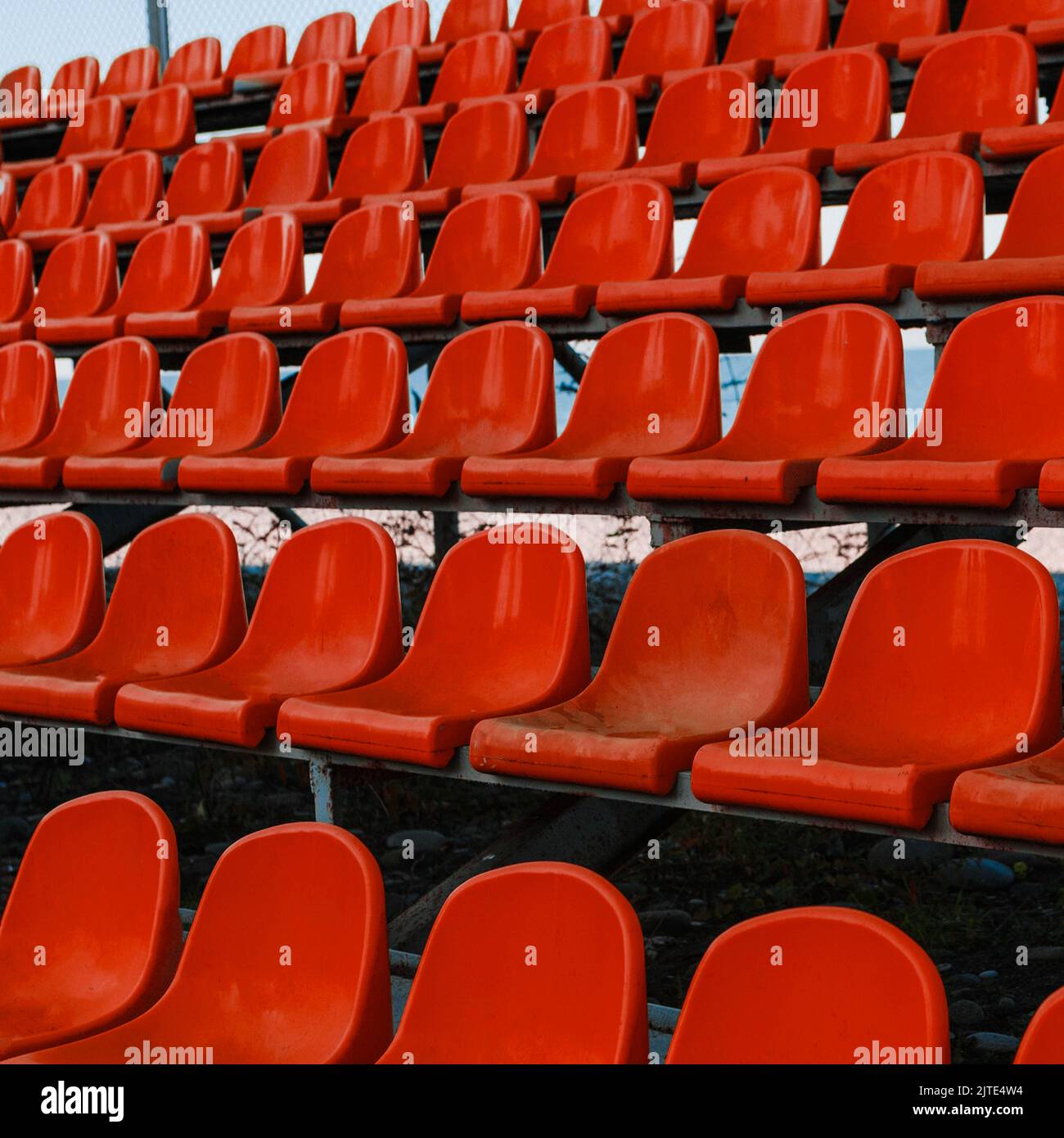 Gros plan sur les sièges en plastique rouges du stade pour le public. Le cliché est sans marque ni personne. Banque D'Images