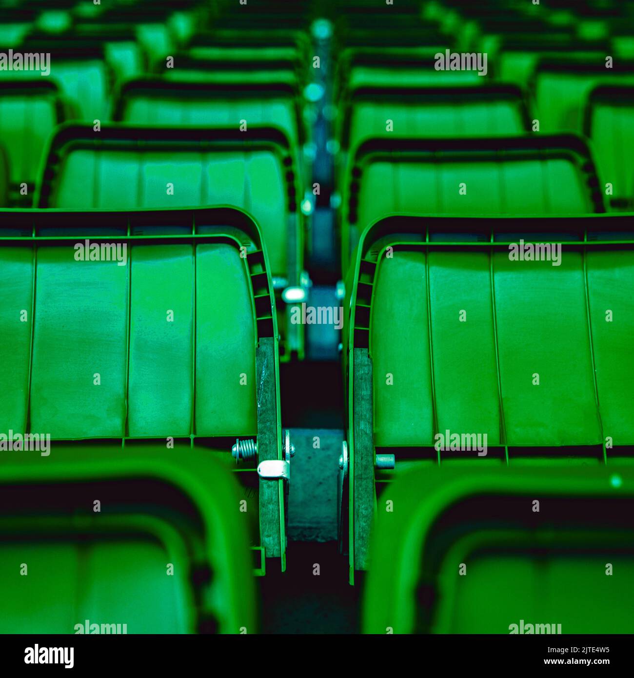 Gros plan des sièges pliants en plastique vert du stade pour le public. Le cliché est sans marque ni personne. Banque D'Images