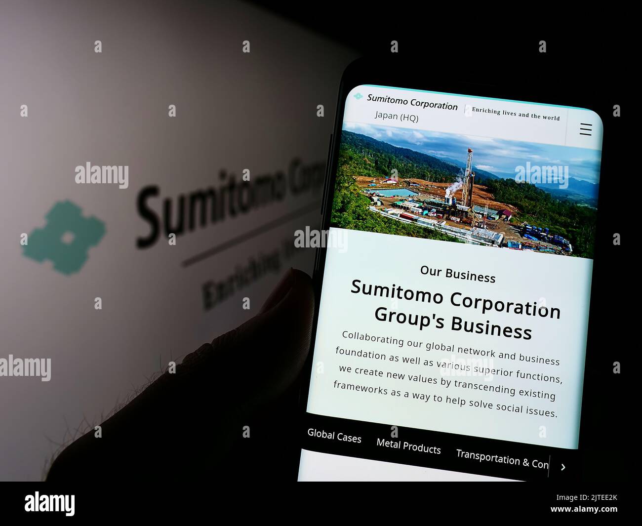 Personne tenant le téléphone portable avec la page Web de la société japonaise Sumitomo Corporation sur l'écran devant le logo. Concentrez-vous sur le centre de l'écran du téléphone. Banque D'Images