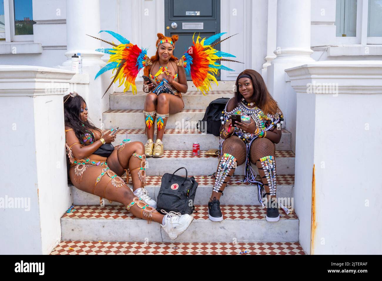 Notting Hill Carnival Grand Parade, le lundi 2022 août, jour férié à Londres, Royaume-Uni. Trois femmes noires se détendent avant la parade à Ladbroke Grove Banque D'Images