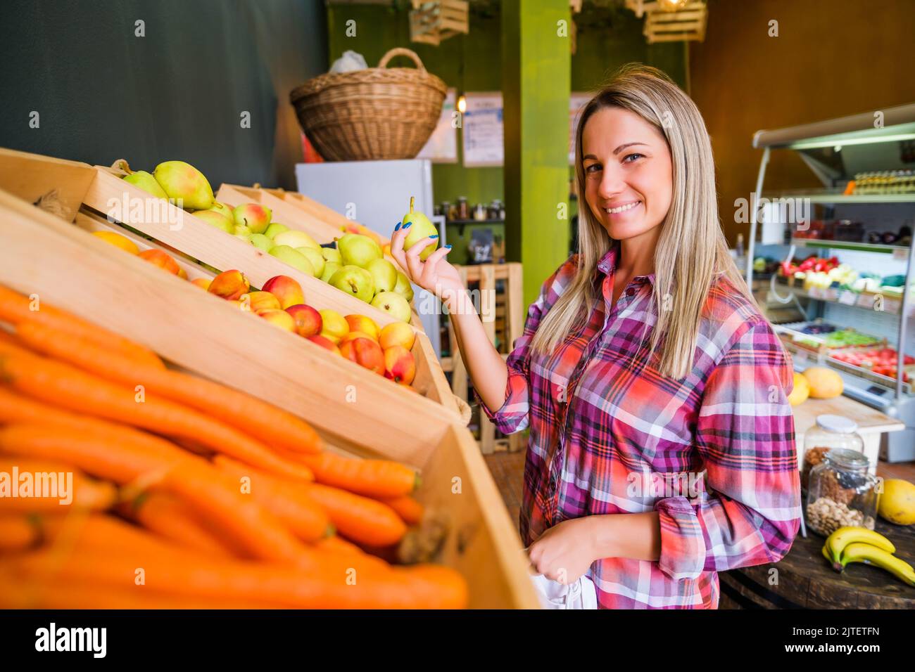 Femme achetant des produits dans la boutique de fruits et légumes. Banque D'Images
