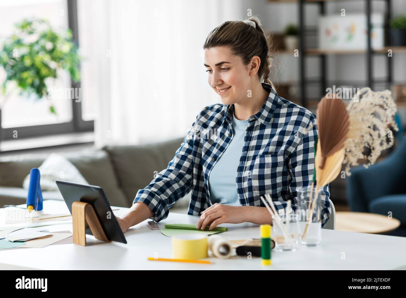 femme avec un tablet pc qui fait du papier à la maison Banque D'Images