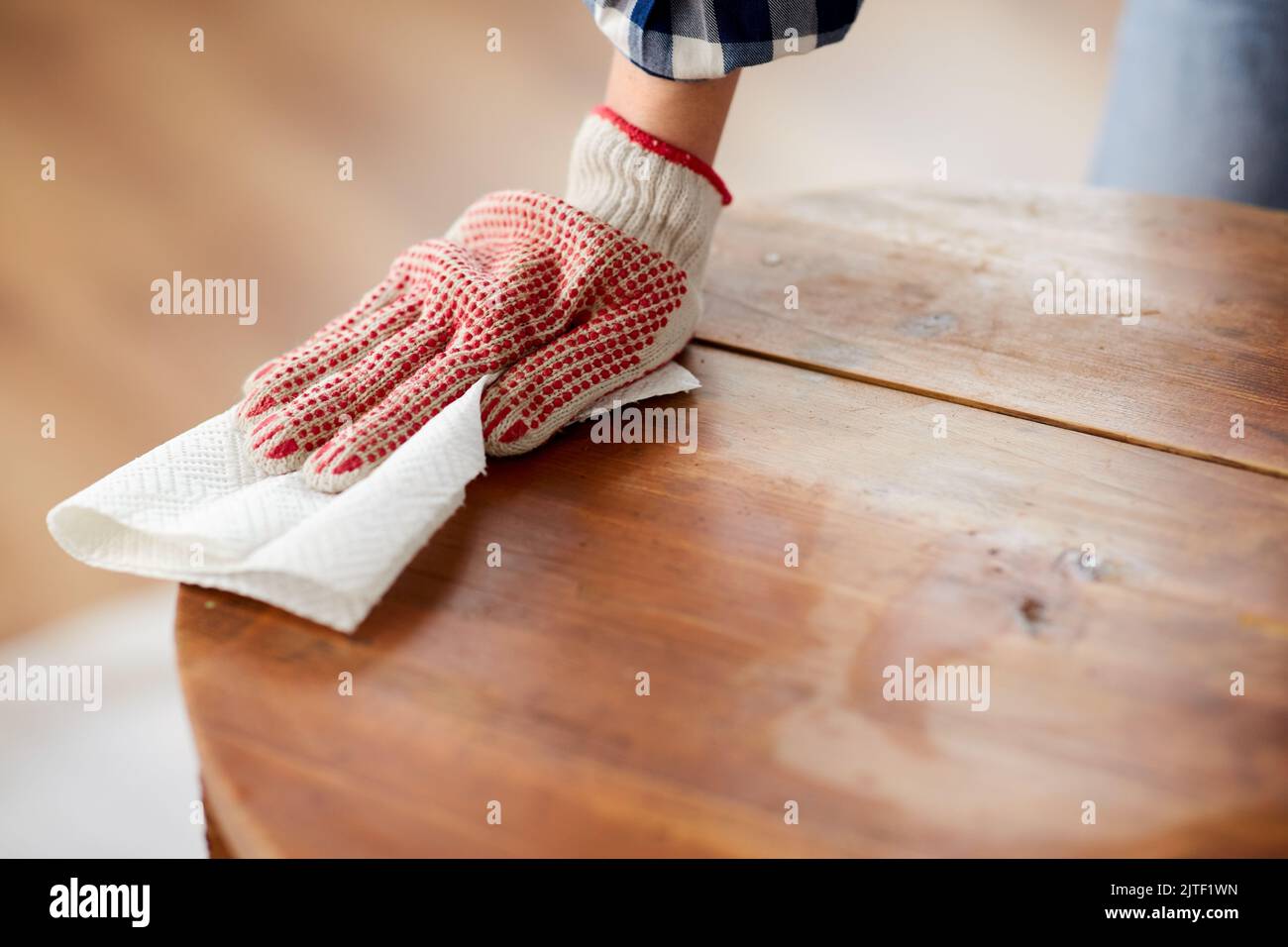 femme nettoyant la surface de la table ancienne avec du papier absorbant Banque D'Images