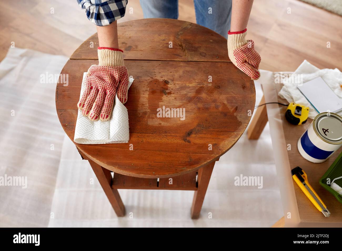 femme nettoyant la surface de la table ancienne avec du papier absorbant Banque D'Images