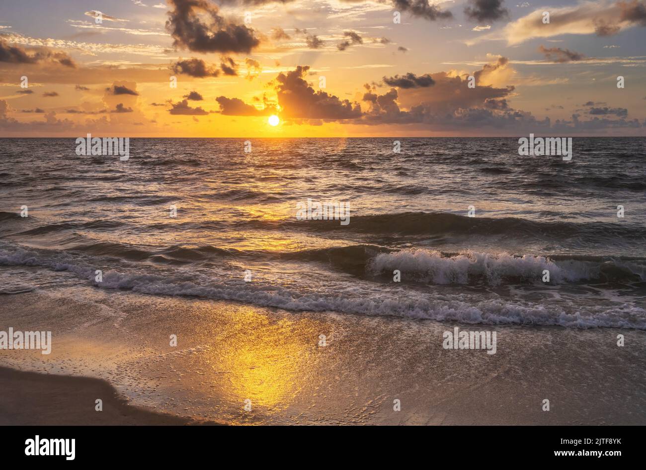 Plage de lavage des vagues de l'océan au lever du soleil Banque D'Images