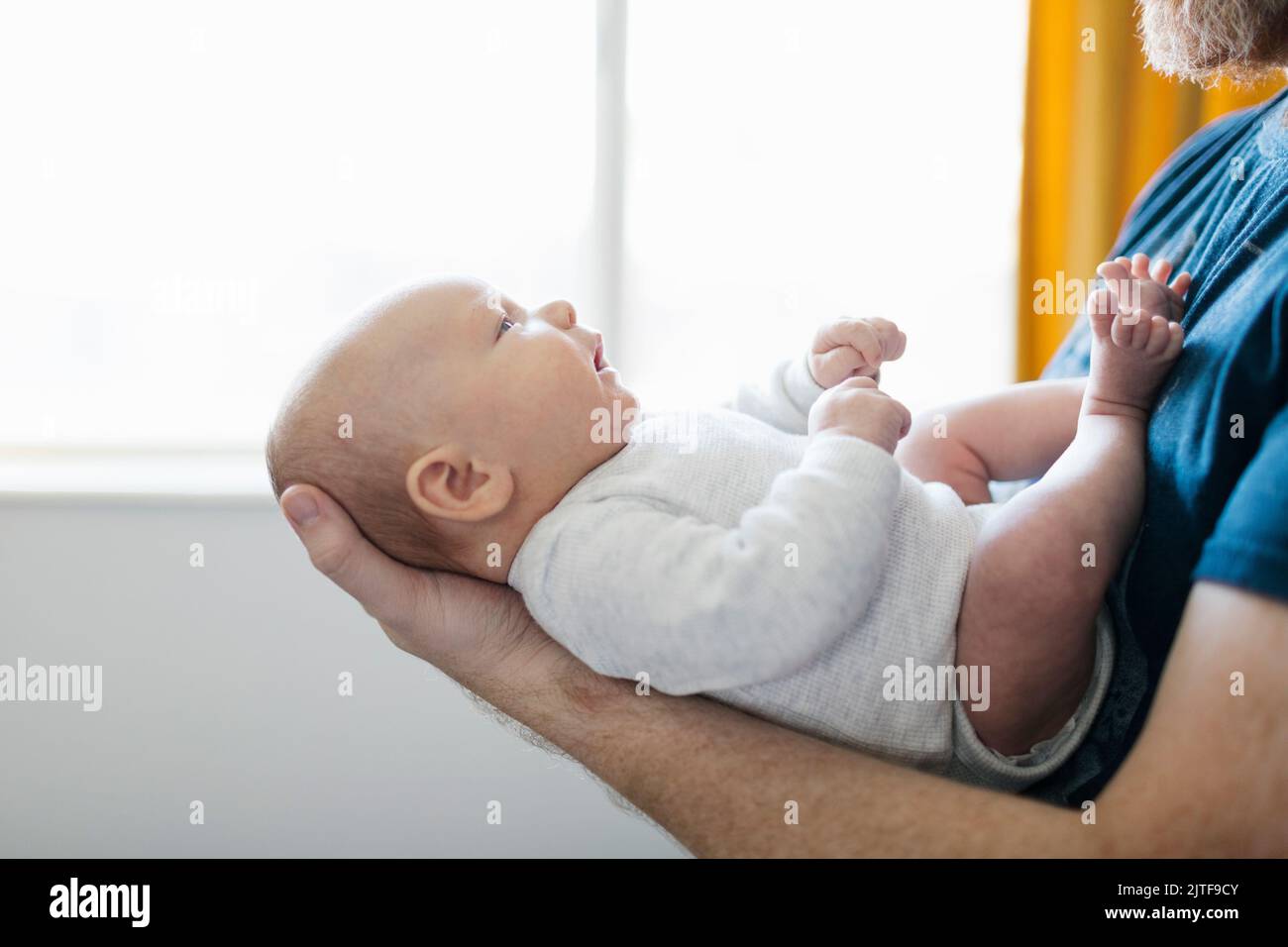 Gros plan du père tenant son nouveau-né (0-1 mois) à la maison Banque D'Images