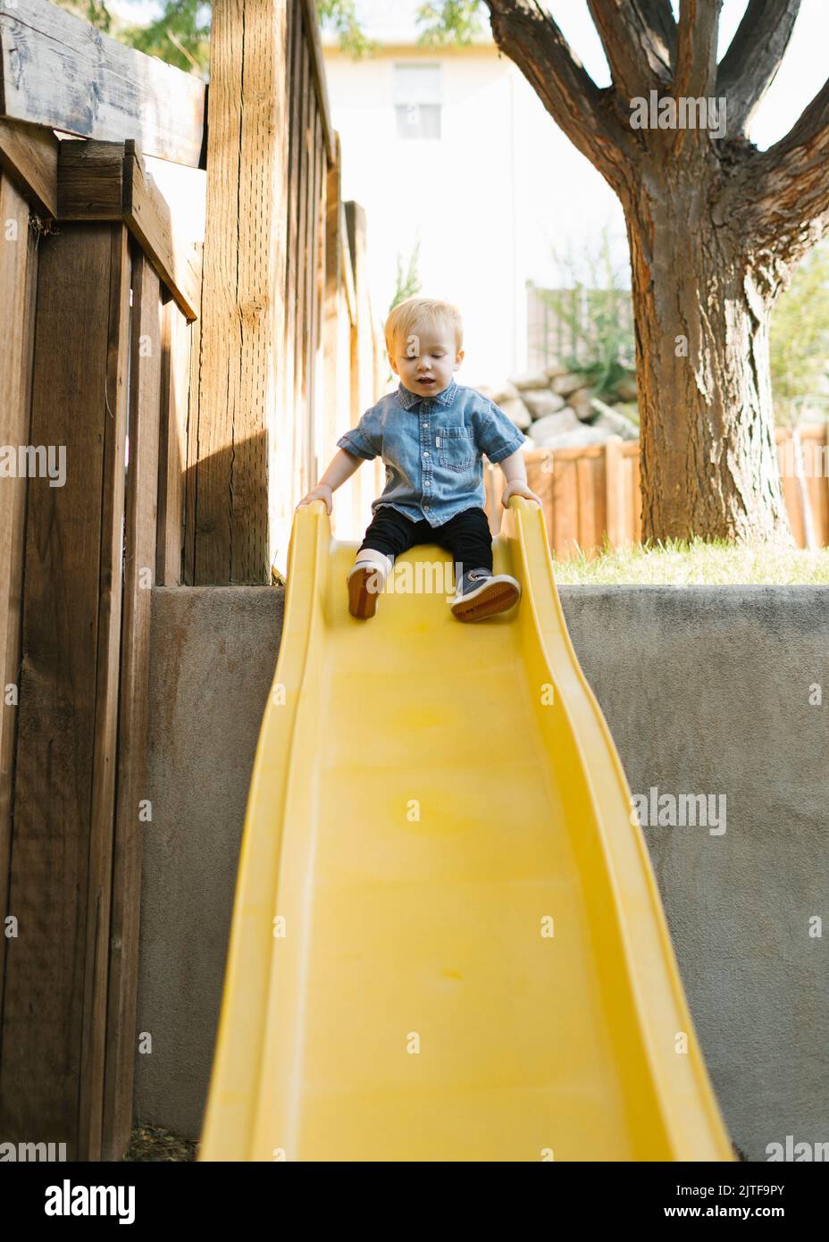 Garçon (2-3) sur le toboggan dans le parc Banque D'Images