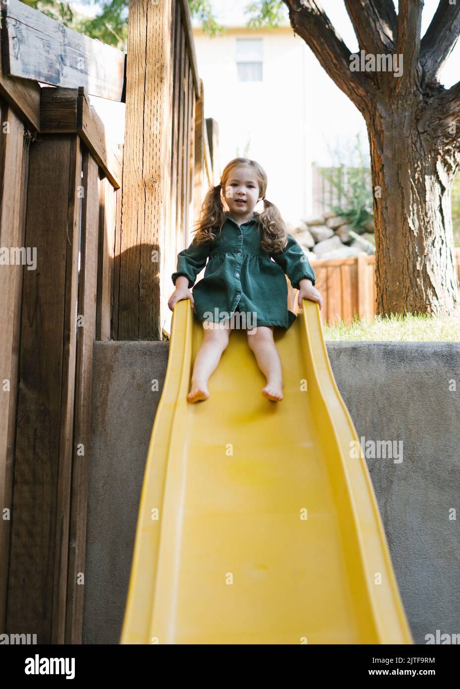 Fille (2-3) sur le toboggan dans le parc Banque D'Images