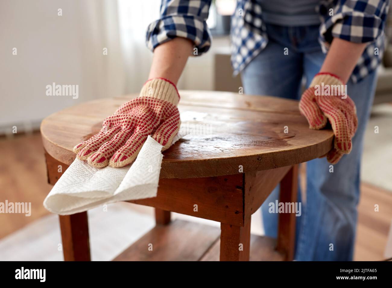 femme nettoyant la surface de la table ancienne avec du papier absorbant Banque D'Images