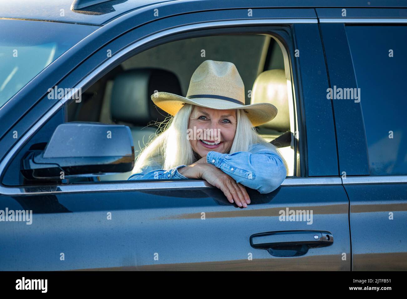 Femme blonde en voiture portant un chapeau de cow-boy Banque D'Images
