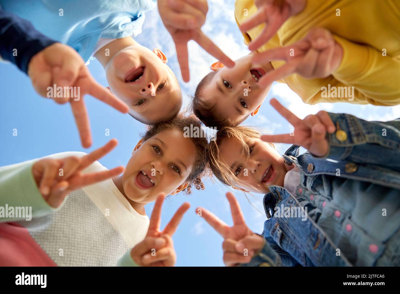 groupe d'enfants heureux montrant le geste de paix Banque D'Images