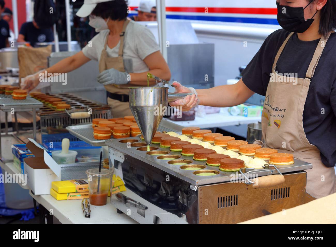 Une personne du Cake roue à la menthe prépare différentes saveurs de gâteaux roue taïwanais 車輪餅 ou imagawayaki à une foire de rue, New York City. Banque D'Images
