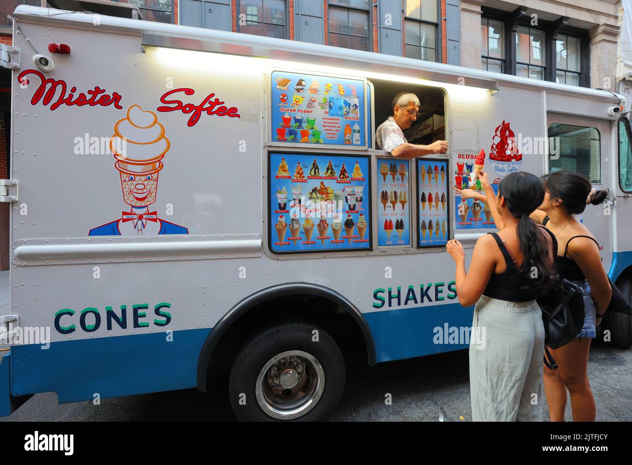 Clients américains asiatiques dans un camion de glace Mister Softee avec un opérateur/chauffeur américain asiatique, New York. Banque D'Images