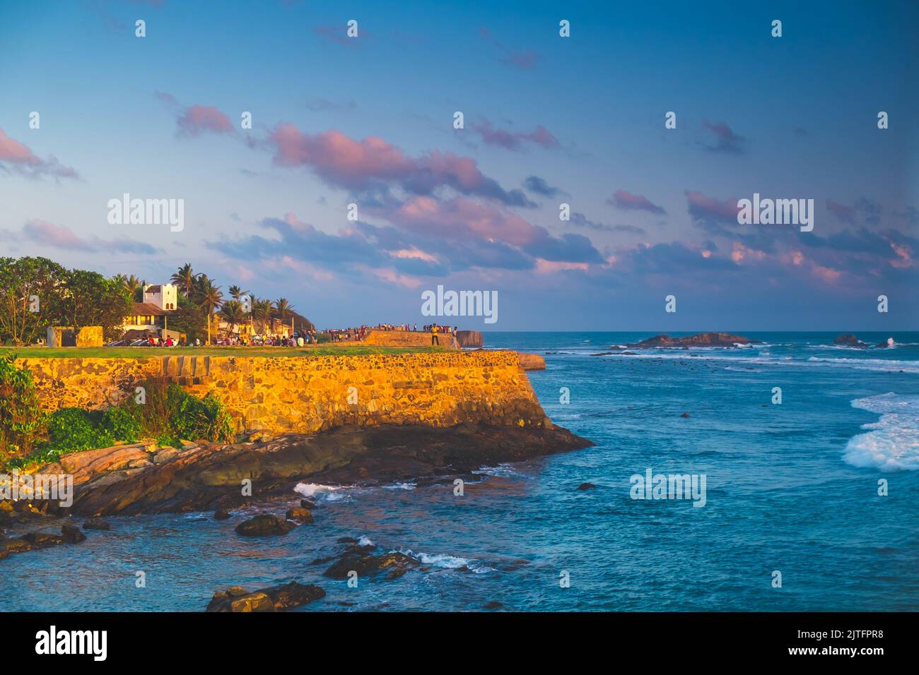 Panorama de fort Galle avec de vieux murs au coucher du soleil lumière orange sur ciel bleu avec des nuages roses, océan en arrière-plan. La plus grande forteresse de la ville et le port de Sri Lanka - destination touristique populaire. Banque D'Images