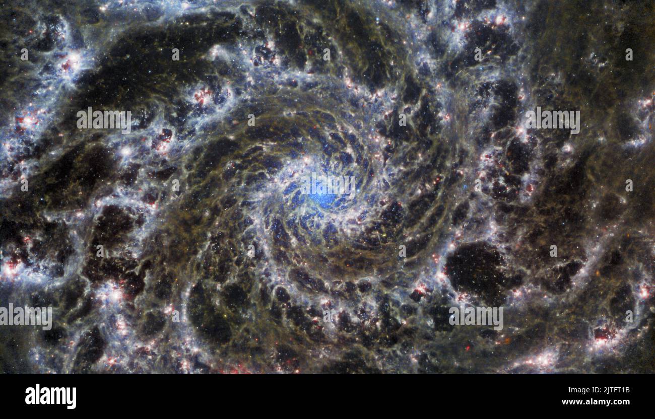 Cette image, publiée sur 29 août 2022, du télescope spatial James Webb NASA/ESA/CSA, montre le cœur de M74, autrement connu sous le nom de Galaxie fantôme. La Galaxie fantôme est à environ 32 millions d'années-lumière de la Terre dans la constellation des poissons et se trouve presque face à la Terre. La vision nette de Webb a révélé des filaments délicats de gaz et de poussière dans les bras en spirale grandiose qui s'enroulent vers l'extérieur depuis le centre de cette image. Un manque de gaz dans la région nucléaire fournit également une vue non obscurcie du noyau d'étoiles nucléaires au centre de la galaxie. M74 est une classe particulière de la galaxie spirale savoir Banque D'Images