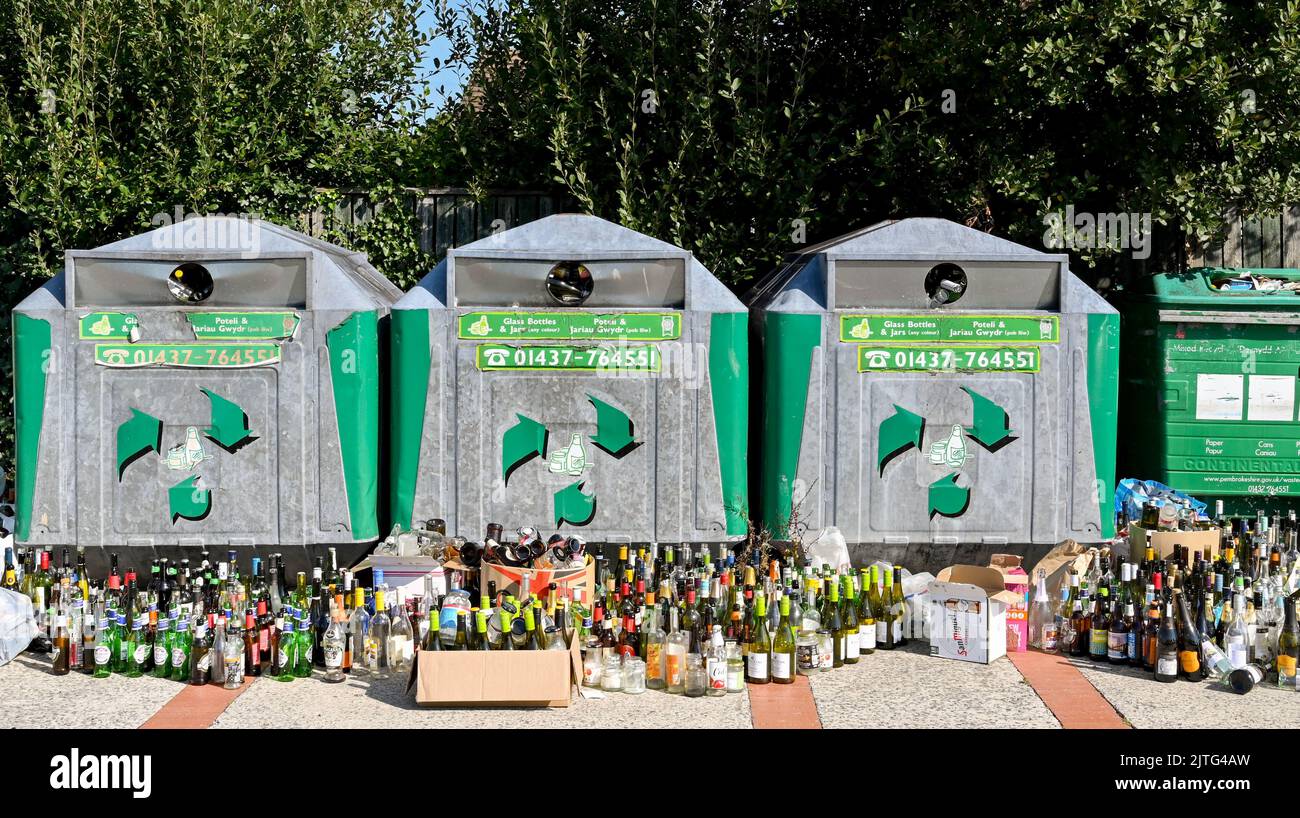Newport, Pembrokeshire, pays de Galles - août 2022 : un grand nombre de bouteilles de vin laissées à côté des bacs de recyclage pleins Banque D'Images