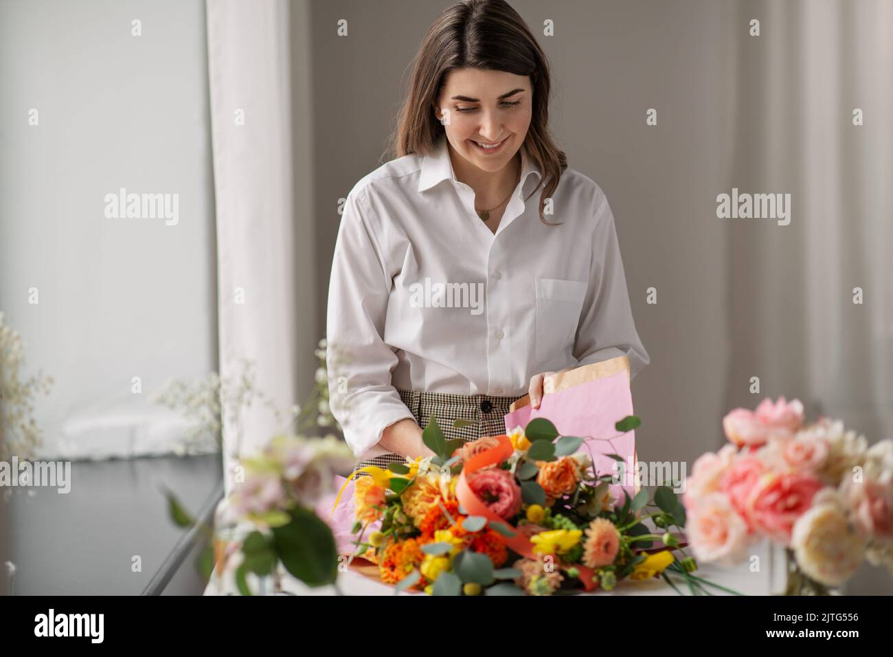 femme emballant des fleurs pour faire du papier à la maison Banque D'Images