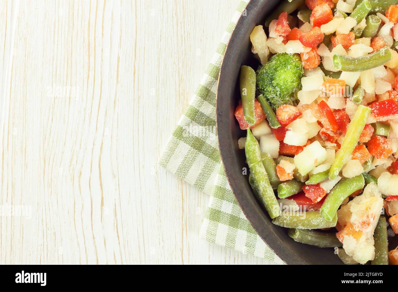 Un mélange de légumes surgelés assortis dans une casserole noire prête