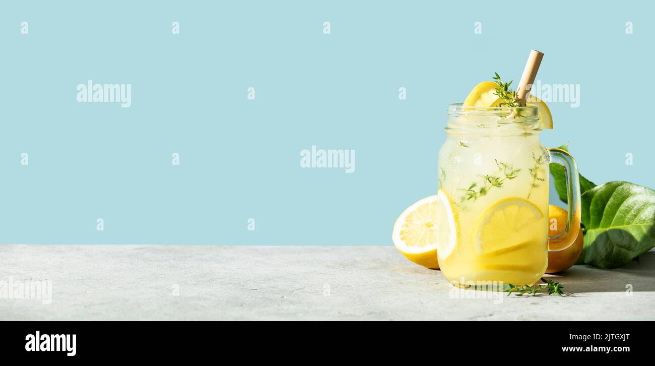 Bannière de la boisson d'été avec citron et romarin gros plan. Boisson rafraîchissante en été. Eau froide de détox avec citron Banque D'Images
