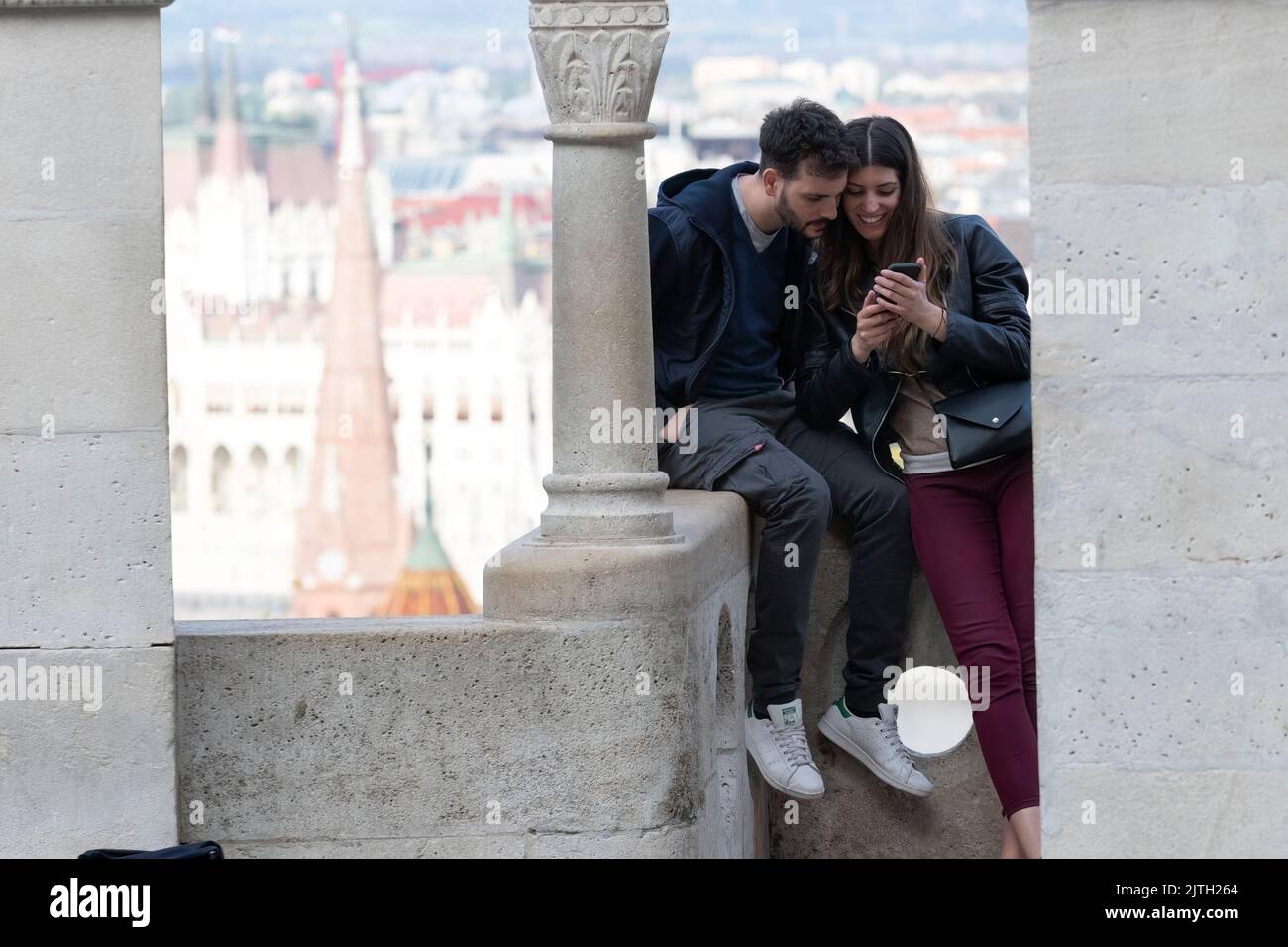 Jeune couple appréciant des photos prises sur leur appareil mobile à une vue panoramique sur le Danube Banque D'Images