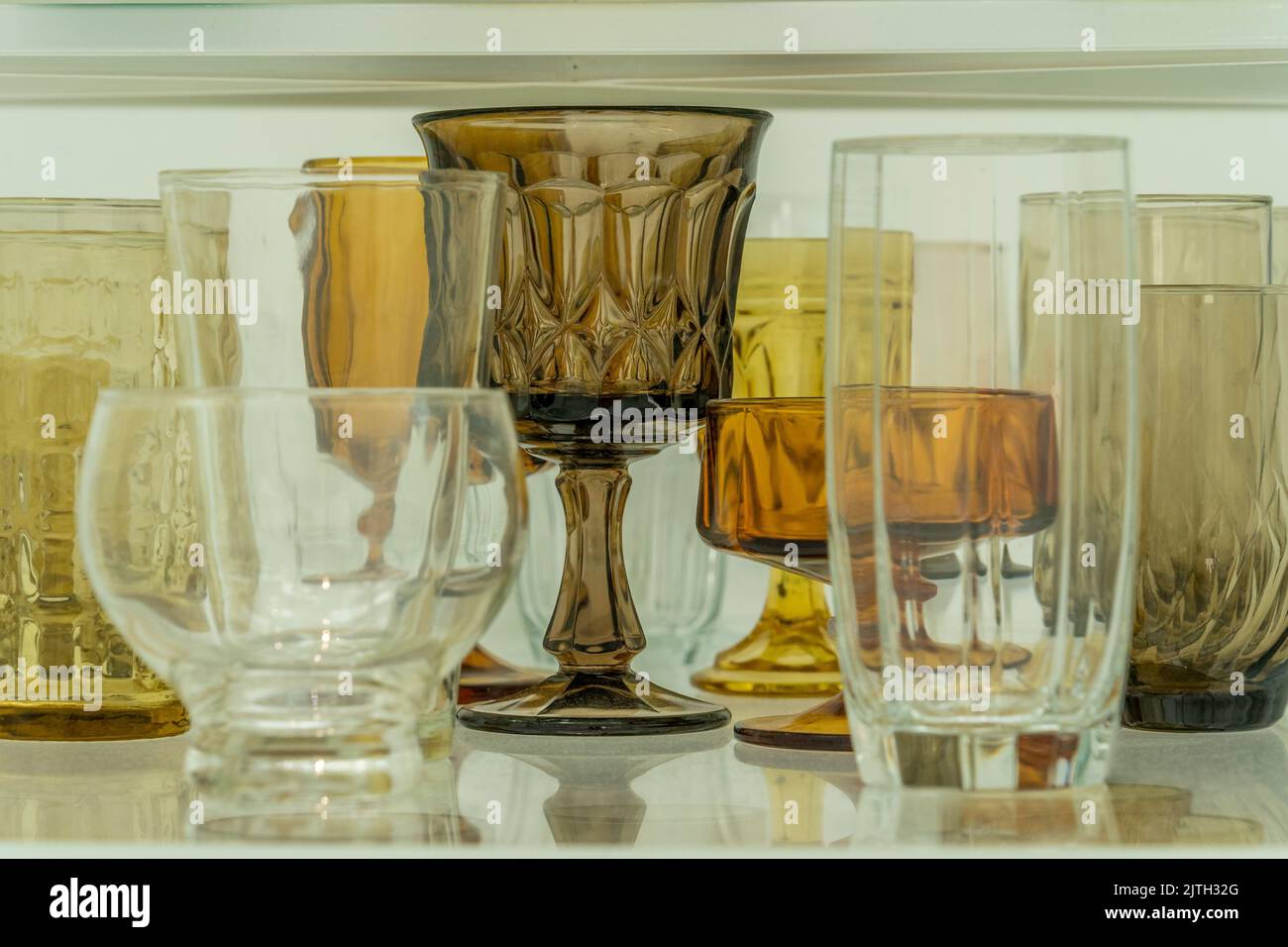 Gros plan de l'assortiment de verres jaunes, bruns, blancs sur une étagère Banque D'Images