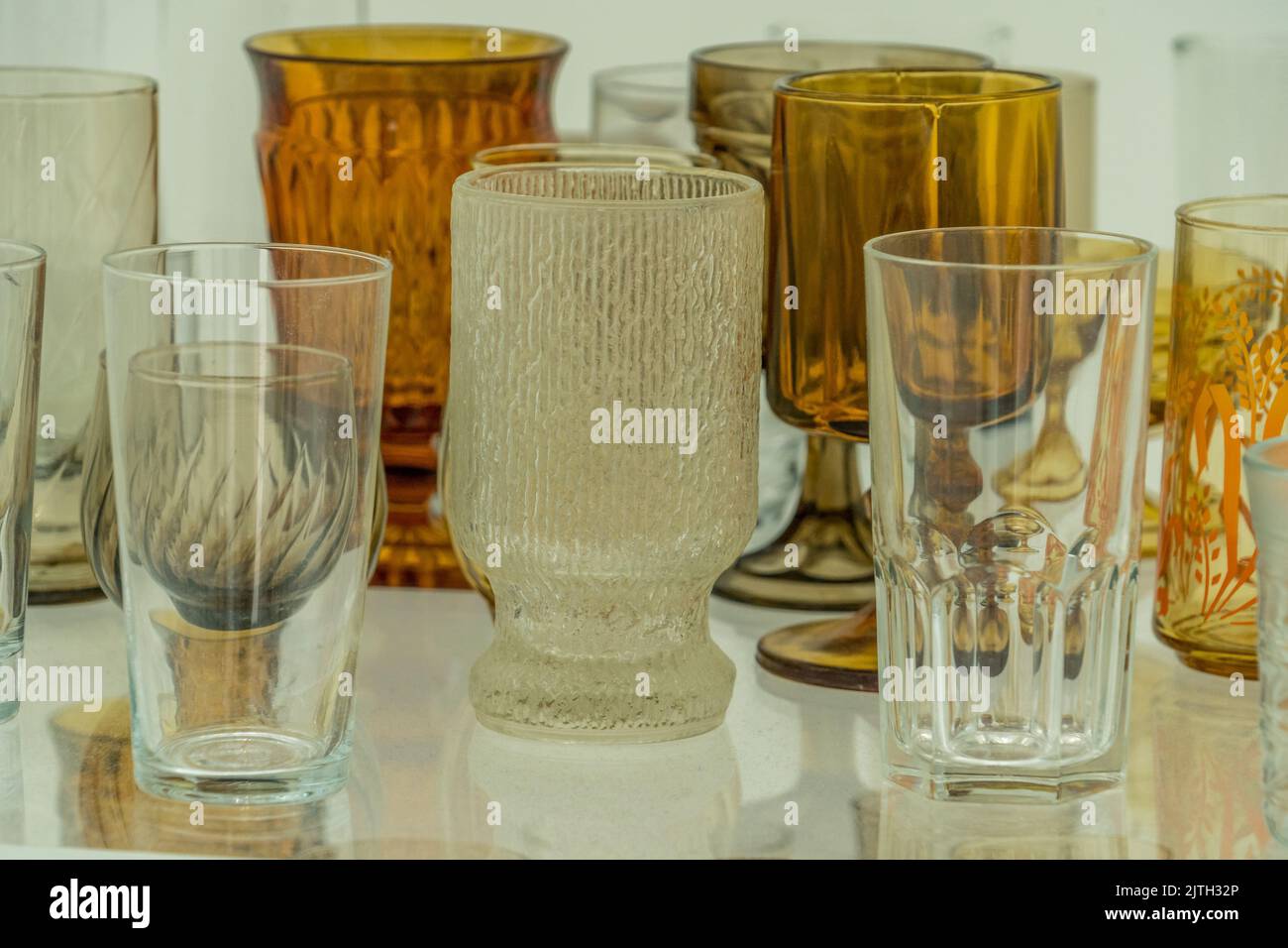 Gros plan de l'assortiment de verres jaunes, bruns, blancs sur une étagère Banque D'Images