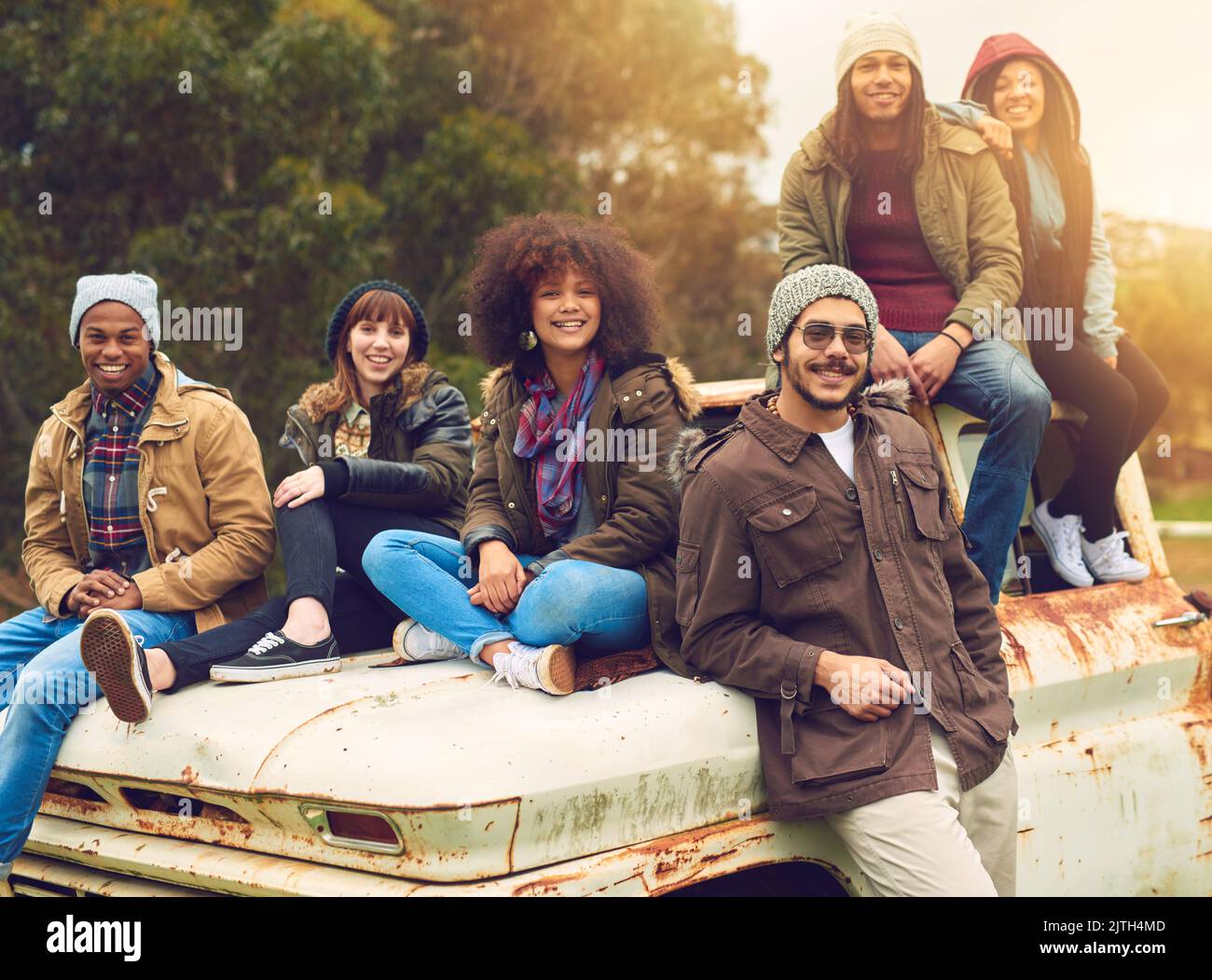 Ce sont les moments que vous vous souvenez toujours. Portrait d'un groupe d'amis posé autour d'un vieux camion dans un champ. Banque D'Images