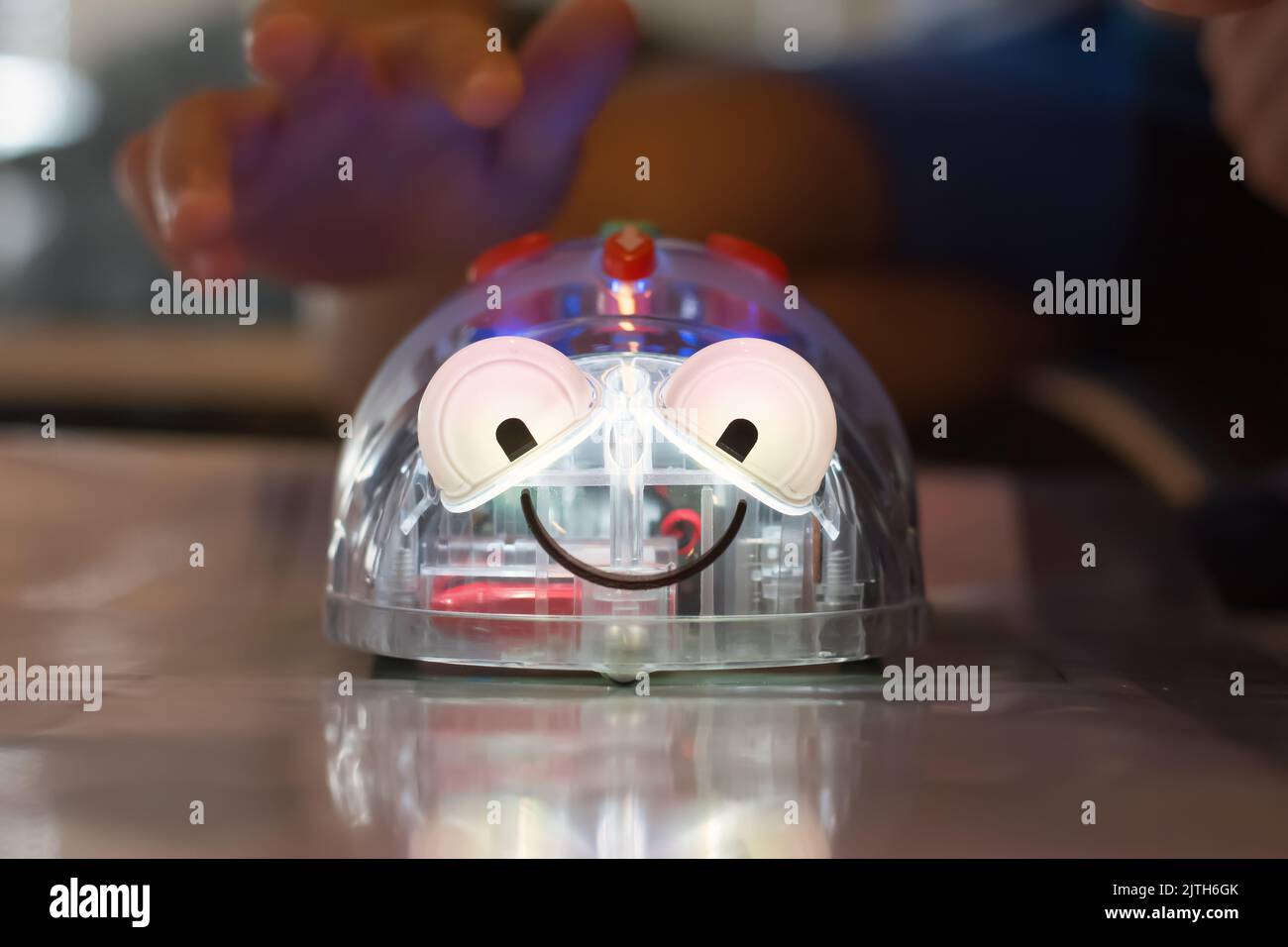 Enfant testant son robot dans un camp de programmation, robot souriant Banque D'Images