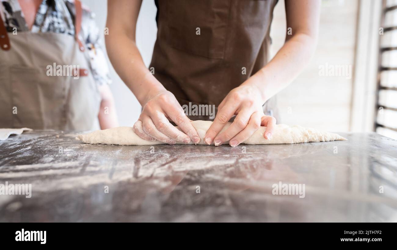 Le processus de fabrication de baguettes traditionnelles françaises. Former un blanc à partir de la pâte. Vue avant. Banque D'Images