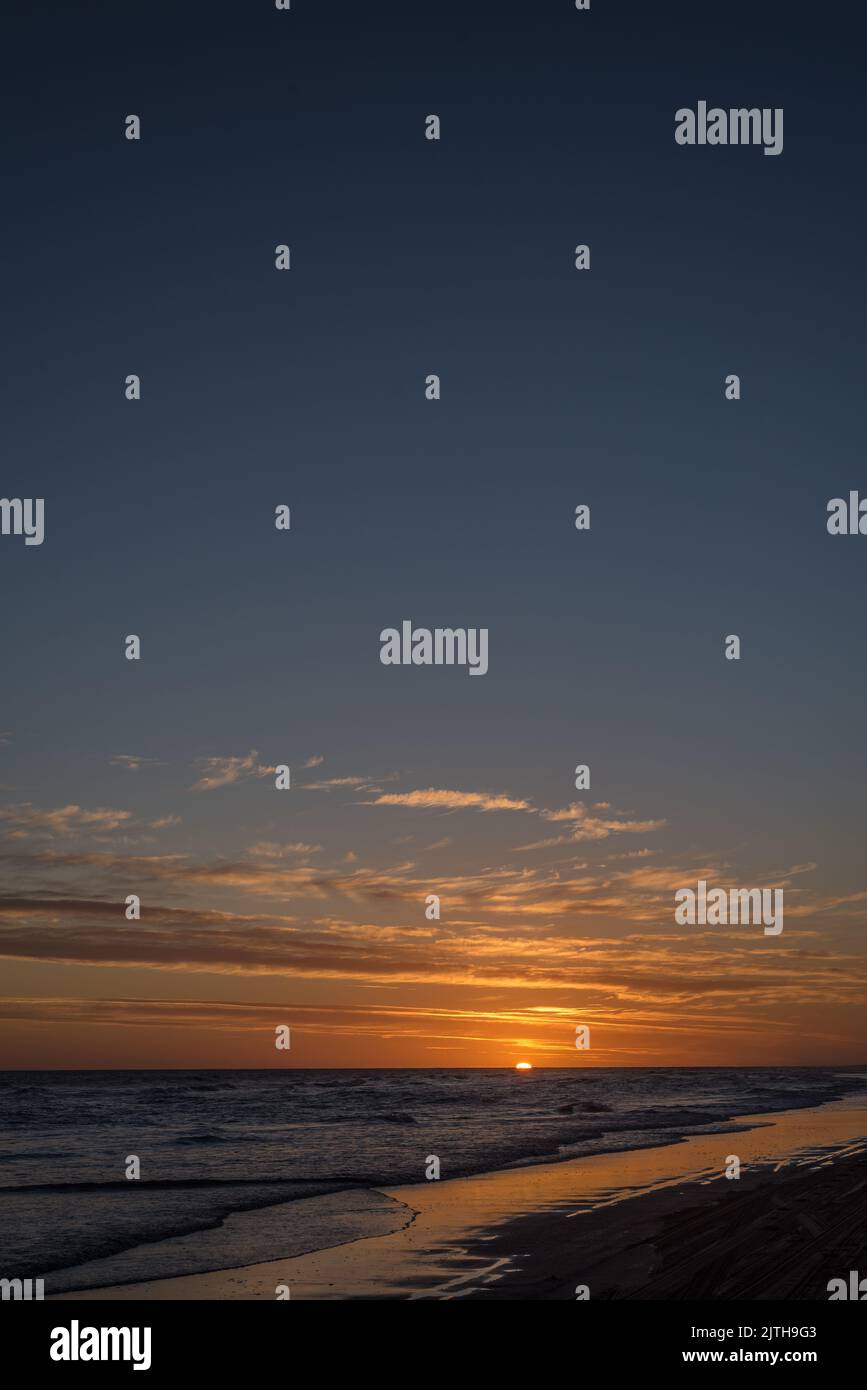 Portrait d'un ciel spectaculaire au coucher du soleil avec nuages et reflet sur la mer. Banque D'Images