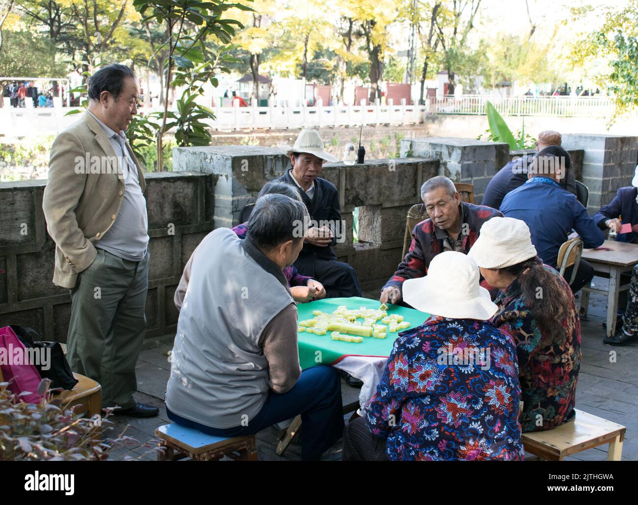 Senior Chinois jouant Mahjong jeu de société sur une table dans un parc public à Kunming . Banque D'Images