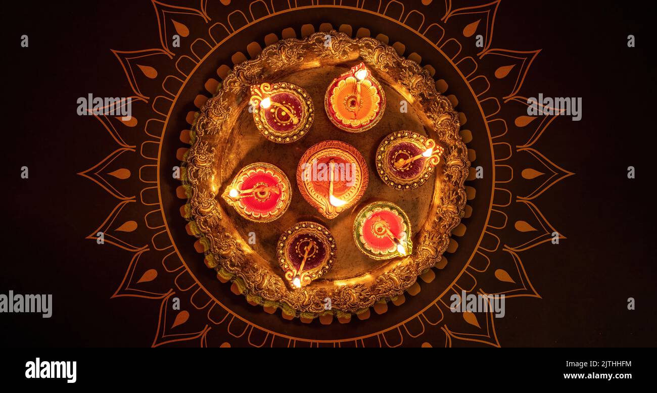 Deepavali Diwali, festival hindou des lumières. Lampe à huile de diya allumée sur Puja thali traditionnel, vue de dessus. Banque D'Images