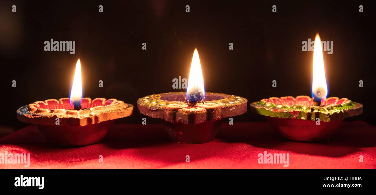 Deepavali Diwali. Festival hindou de lumières. Bougies en argile diyas. Voyants d'huile allumés sur fond sombre, espace de copie. Banque D'Images