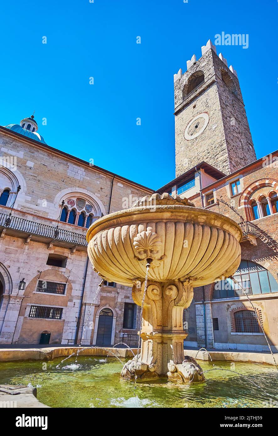 La fontaine médiévale en pierre dans la cour du Palazzo Broletto avec Torre del pegol en arrière-plan, Brescia, Italie Banque D'Images