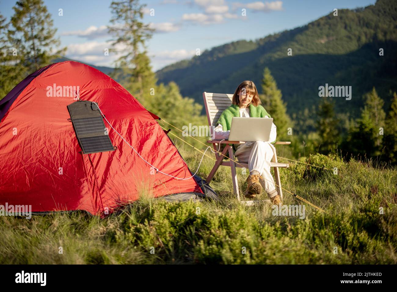 Femme travaille sur ordinateur portable au camping dans les montagnes Banque D'Images