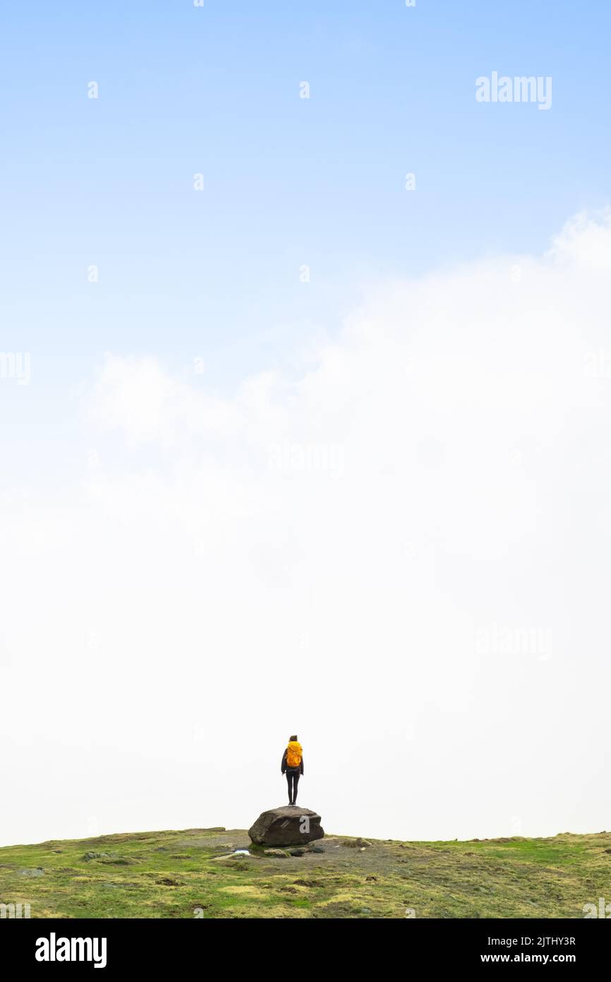 Fille sur un rocher à la recherche de la voie de l'avant dans le brouillard dans le Parc National des Pyrénées, France. Concept de recherche de solutions Banque D'Images