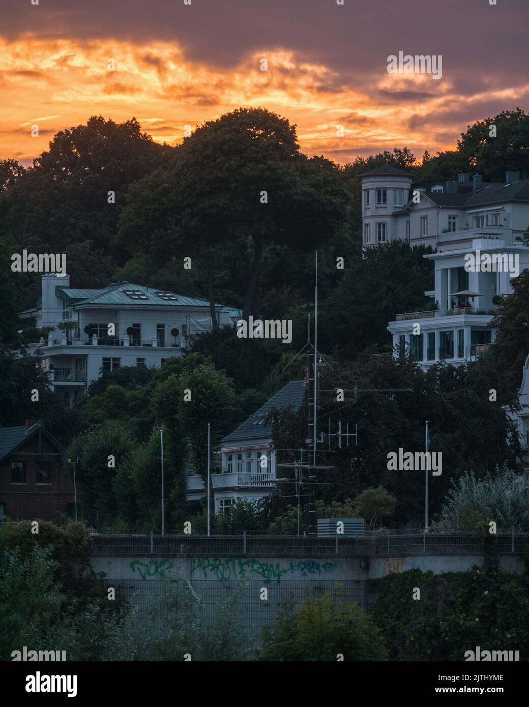 Vue sur le coucher du soleil depuis la plage, vue vers le haut vers les maisons et les nuages Banque D'Images