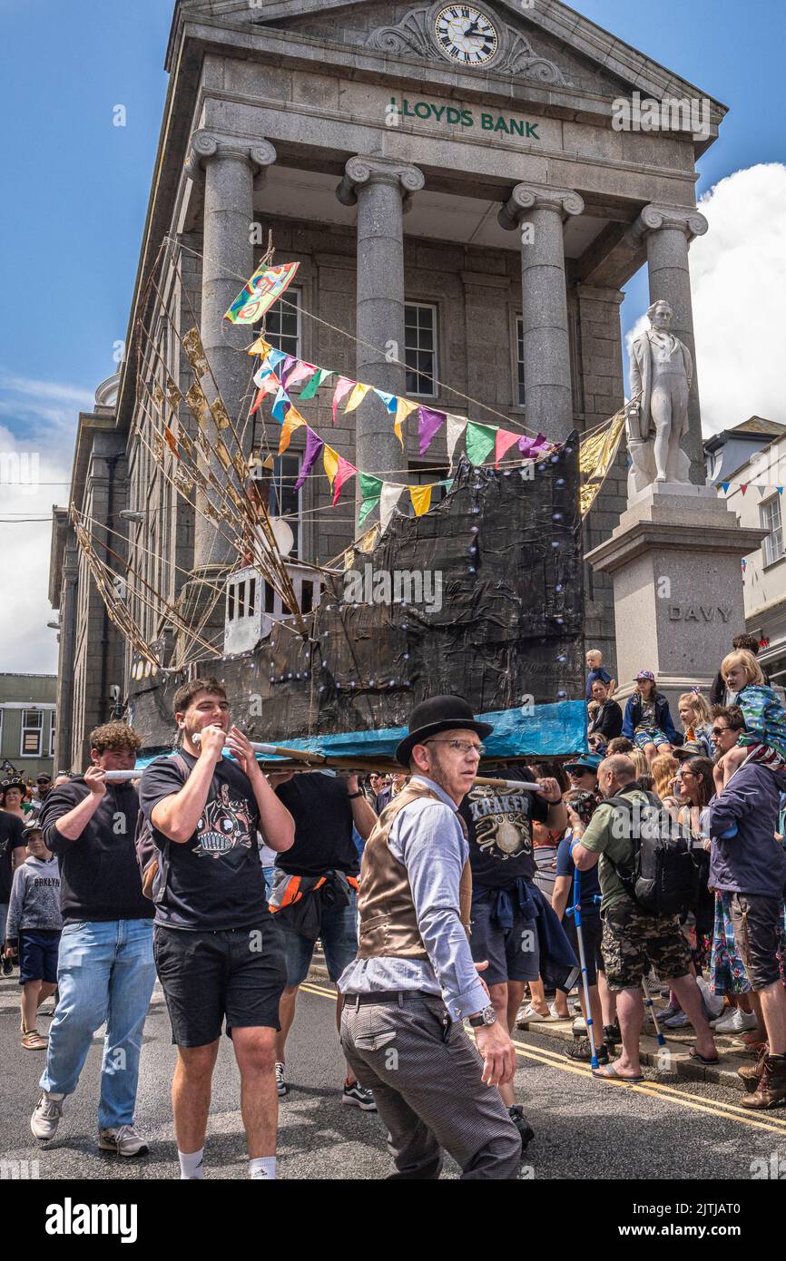 Un grand modèle de réplique d'un chalutier de pêche fait de flétrisettes et de papier dans les célébrations du défilé de la Journée Mazey dans le cadre de la Festiva Golowan Banque D'Images