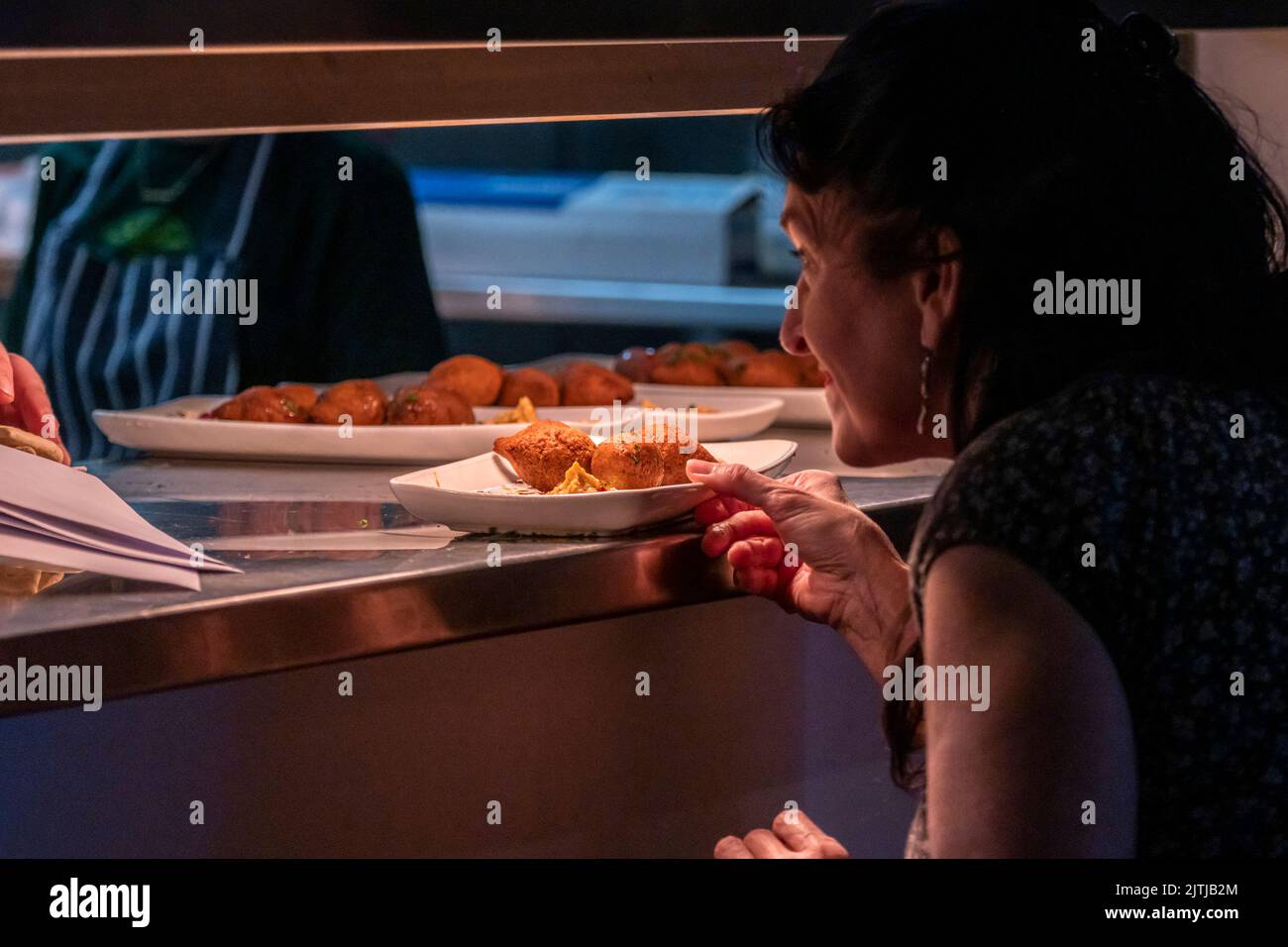 Un volontaire collectant des plats de Kibbeh Ood au col pour servir à un festin du Moyen-Orient en soutien aux réfugiés de Falmouth et Penryn Bienvenue à T Banque D'Images