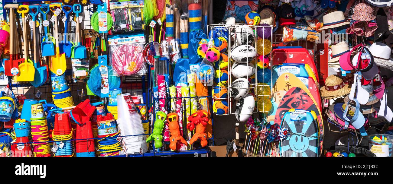 Une image panoramique d'une exposition colorée de jouets et de nouveautés de plage à l'extérieur d'une boutique à Newquay, en Cornouailles, au Royaume-Uni. Banque D'Images