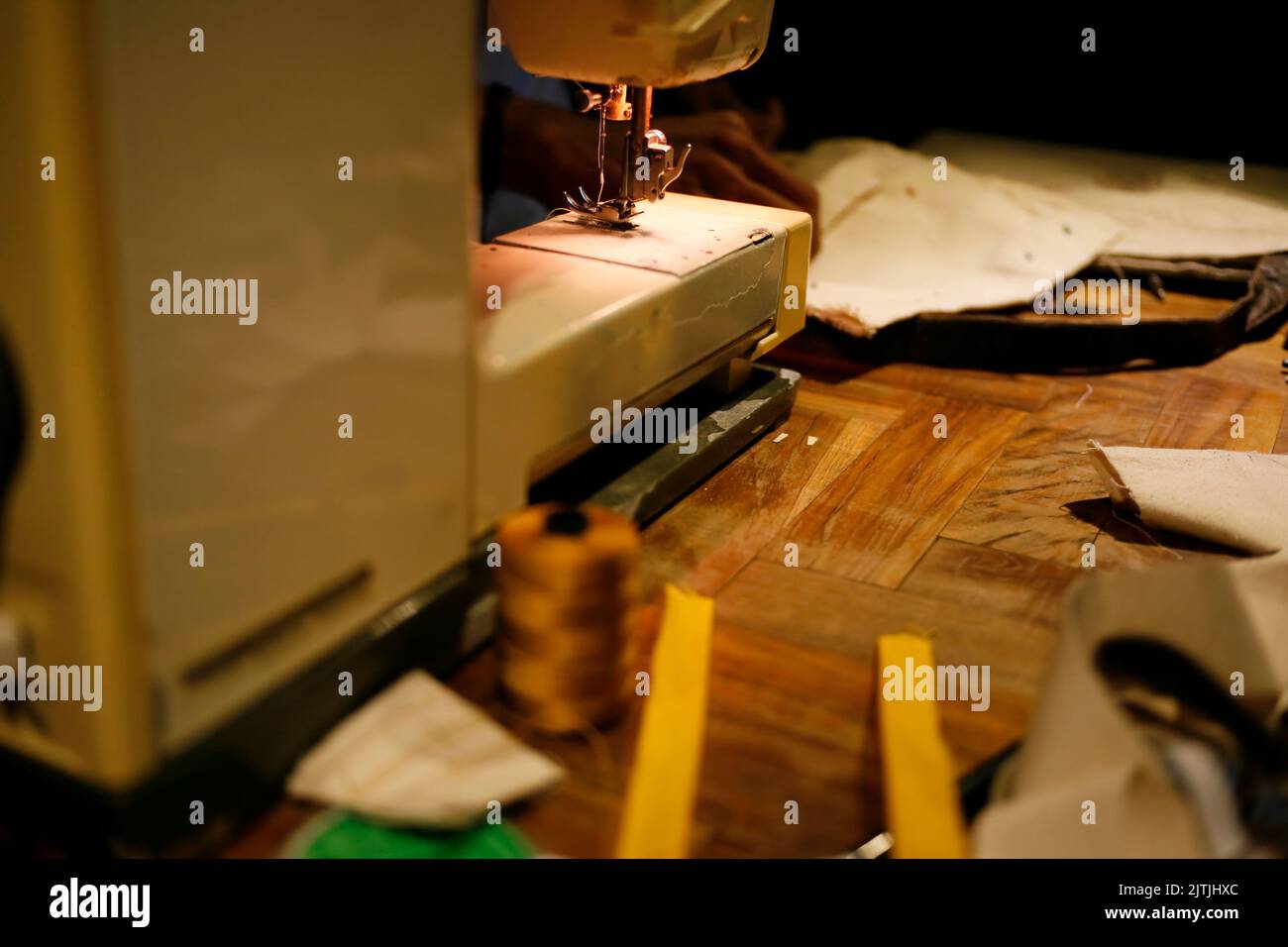 Gros plan de la main travaillant sur la machine à coudre sur la table dans l'atelier de Tailor Banque D'Images