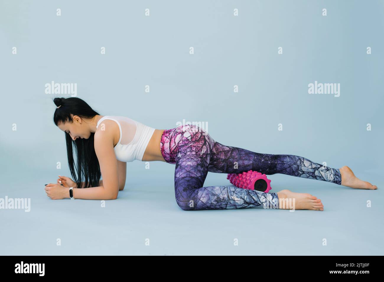 Massage relaxant myofascial Fitness, une fille en forme faisant le fascia s'étendant dans un studio sur un fond bleu le concept de bien-être, santé, style de vie, s Banque D'Images