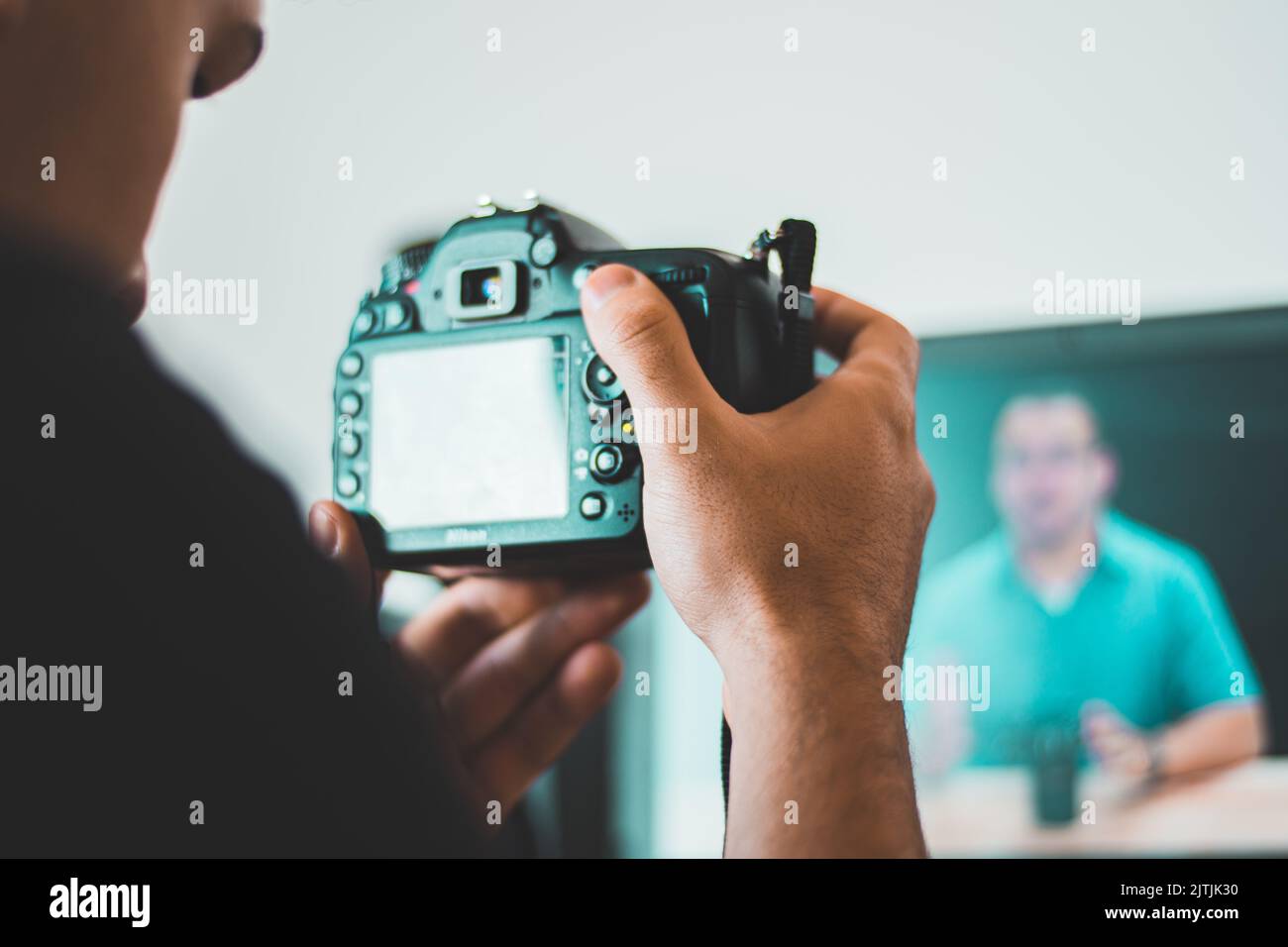 Apprentissage de la photographie, vidéographie à partir d'un cours en ligne tout en tenant un appareil photo reflex numérique à l'avant de l'écran Banque D'Images
