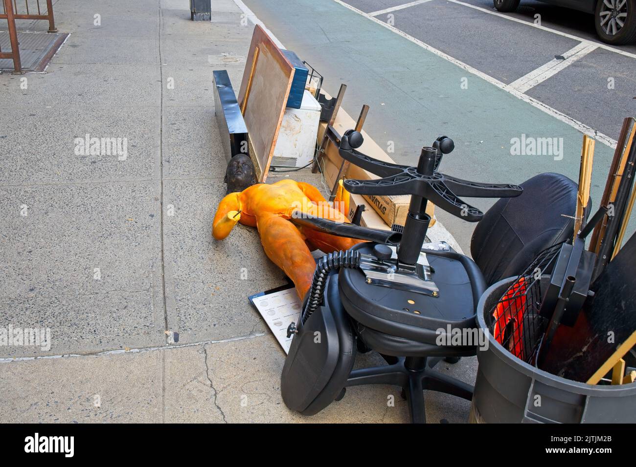 New York, NY, États-Unis - 30 août 2022 : articles qui sont jetés sur le trottoir d'un magasin de costumes à proximité qui causent le passage à se faire effrayer Banque D'Images