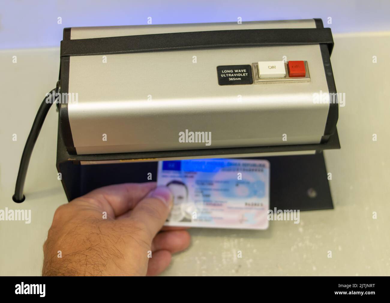 Vérification de la validité d'un document d'identification personnel sous lumière ultraviolette Banque D'Images