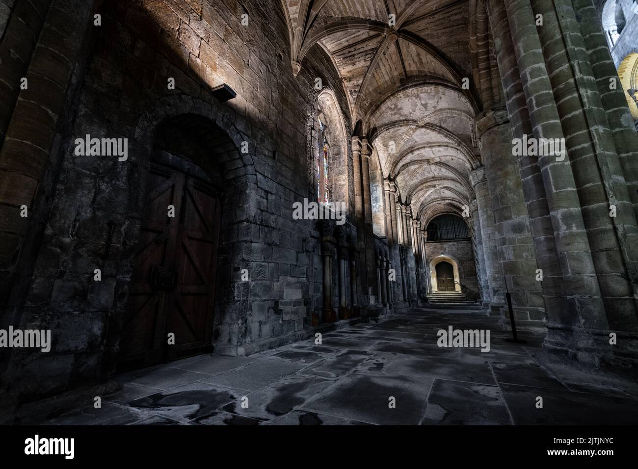 L'intérieur d'une ancienne cathédrale en pierre avec des piliers, des arches et de grandes fenêtres en Écosse, au Royaume-Uni Banque D'Images
